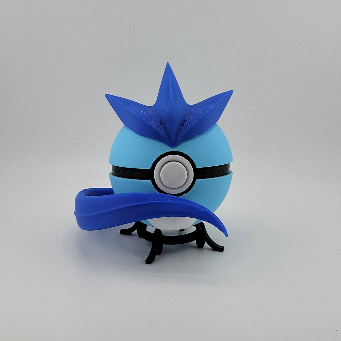 3D printed Articuno-themed Pokeball with blue spikes and tail detail on a black stand, collectible Pokémon fan item