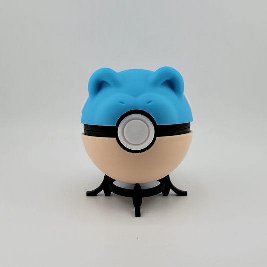 Spheal Ball toy with blue top and cream bottom on display stand.