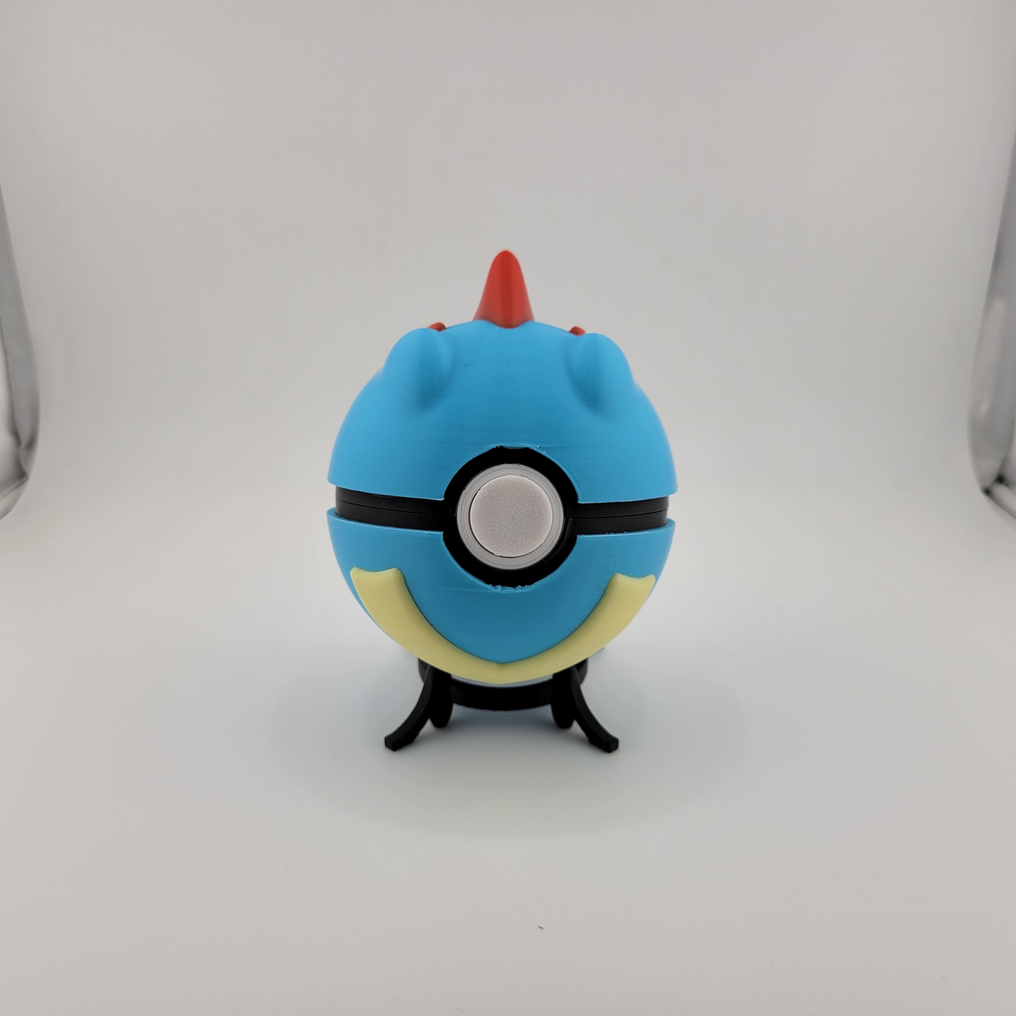 Totodile Pokeball collectible toy on display stand.