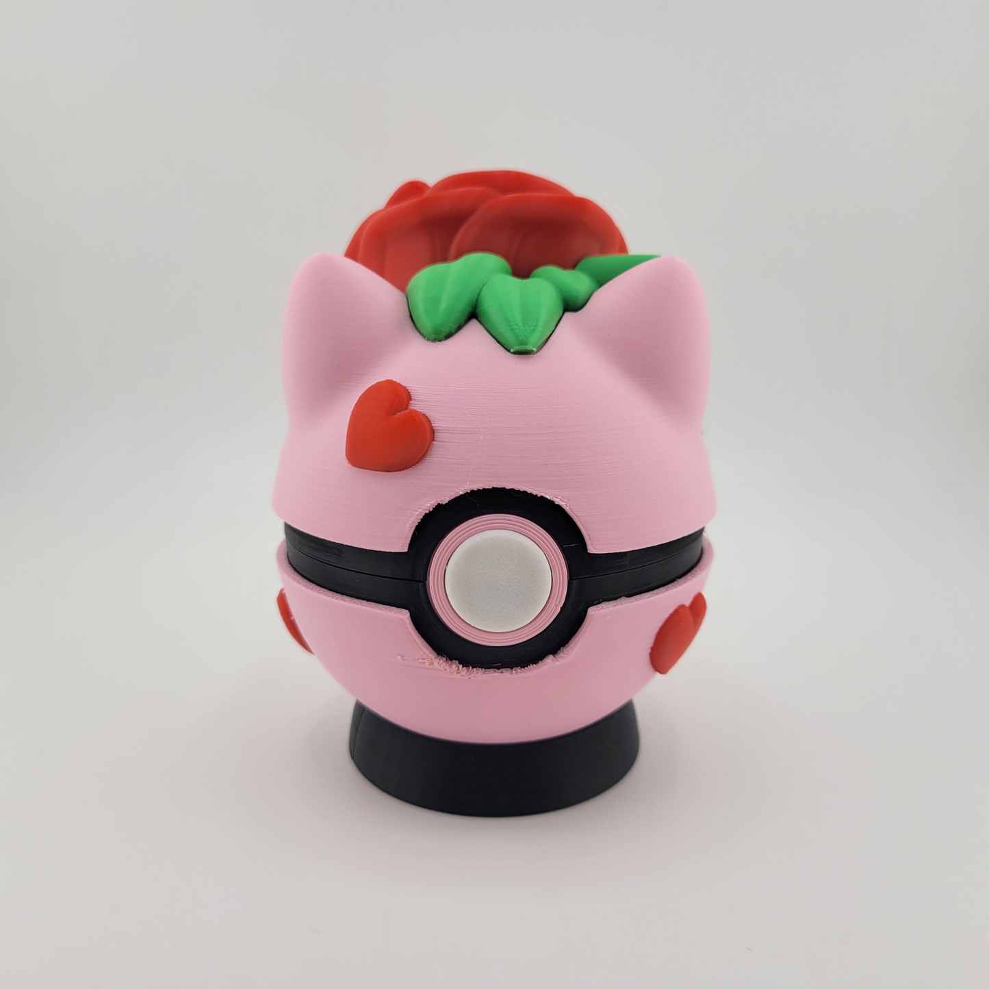 Rose Bulbasaur Pokéball with pink and red rose-inspired design, featuring Bulbasaur motifs.