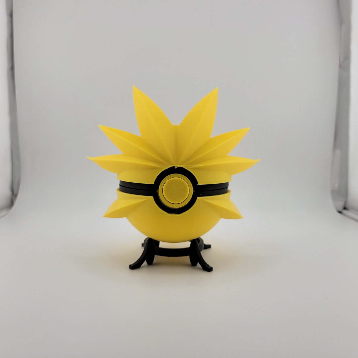 Zapdos Pokeball with dynamic yellow spikes on display stand.