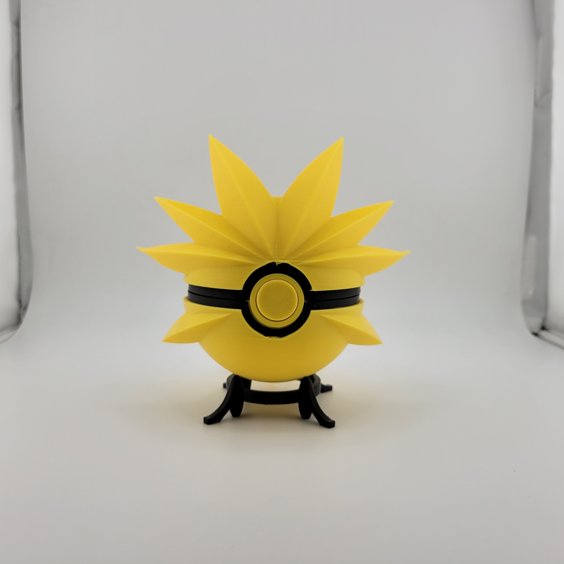 Zapdos Pokeball with dynamic yellow spikes on display stand.