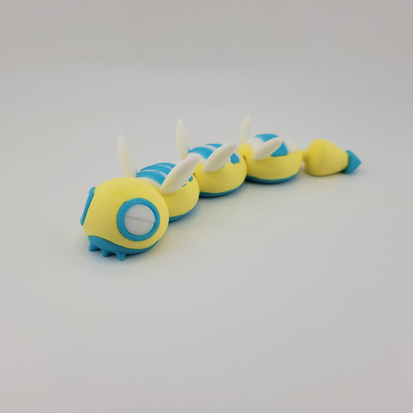 3D printed articulated Dudunsparce Pokémon figure with yellow and blue details.