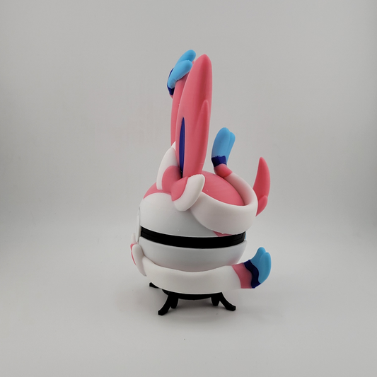3D printed Sylveon-themed Pokéball in pastel pink, blue, and white with ribbon motifs, durable PLA plastic collectible.