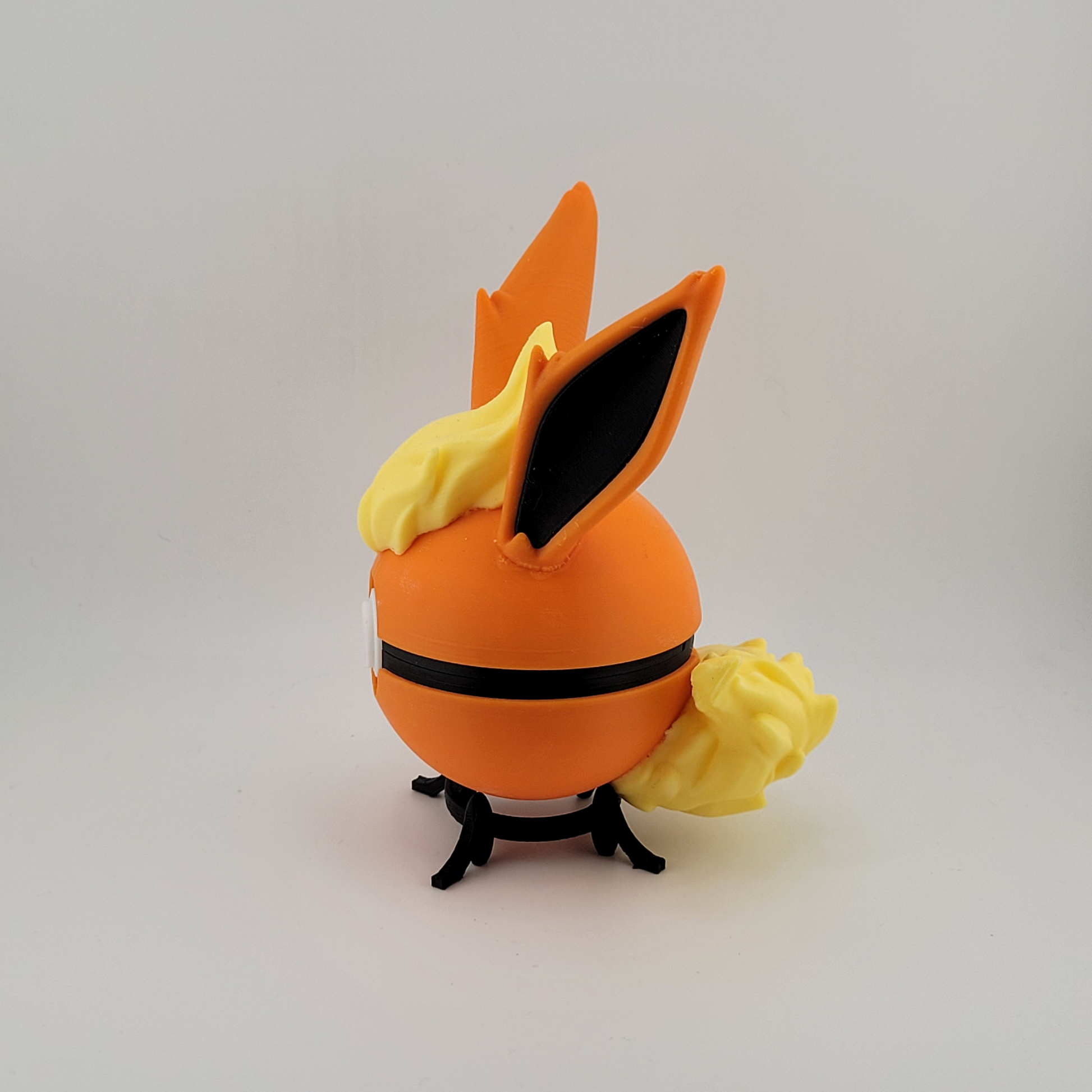 Flareon-themed Pokeball with vivid orange and yellow design, crafted from durable PLA plastic for display and gentle play.
