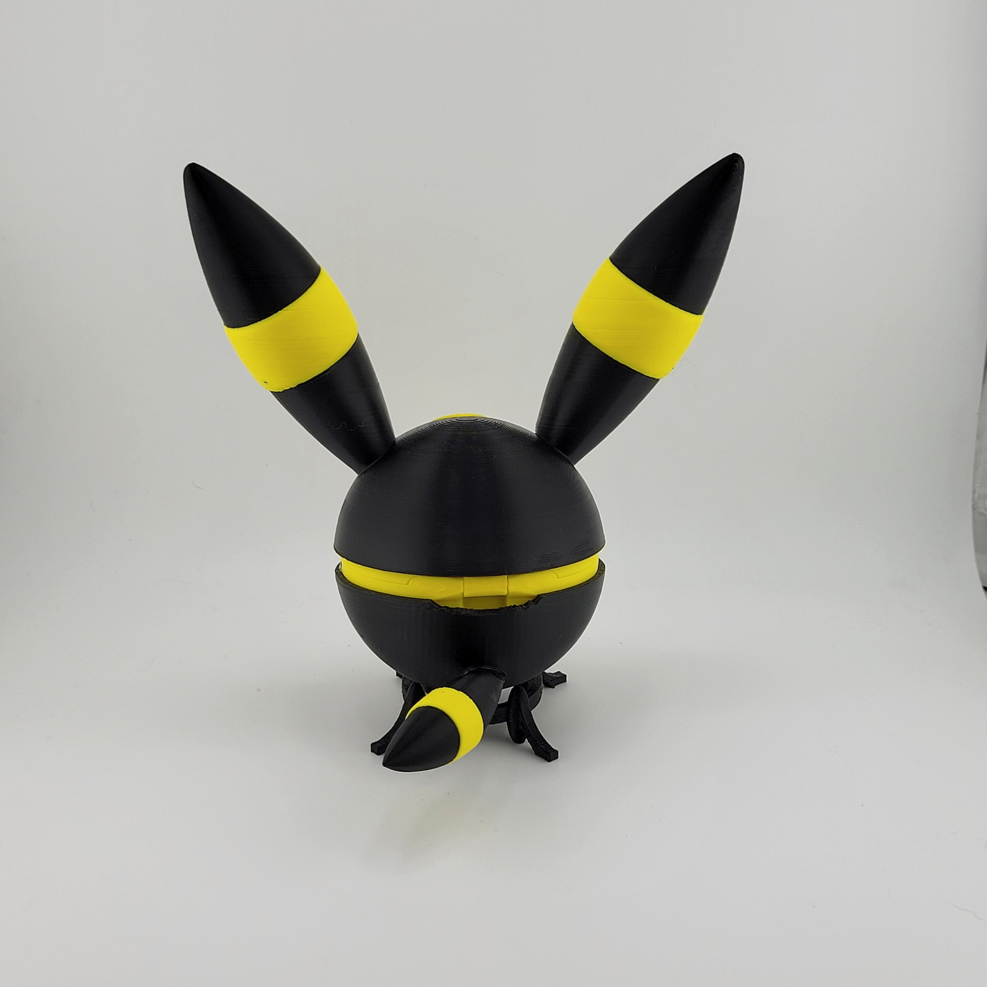3D printed Umbreon Pokeball with black and yellow ears and tail, inspired by the Dark-type Pokémon Umbreon.