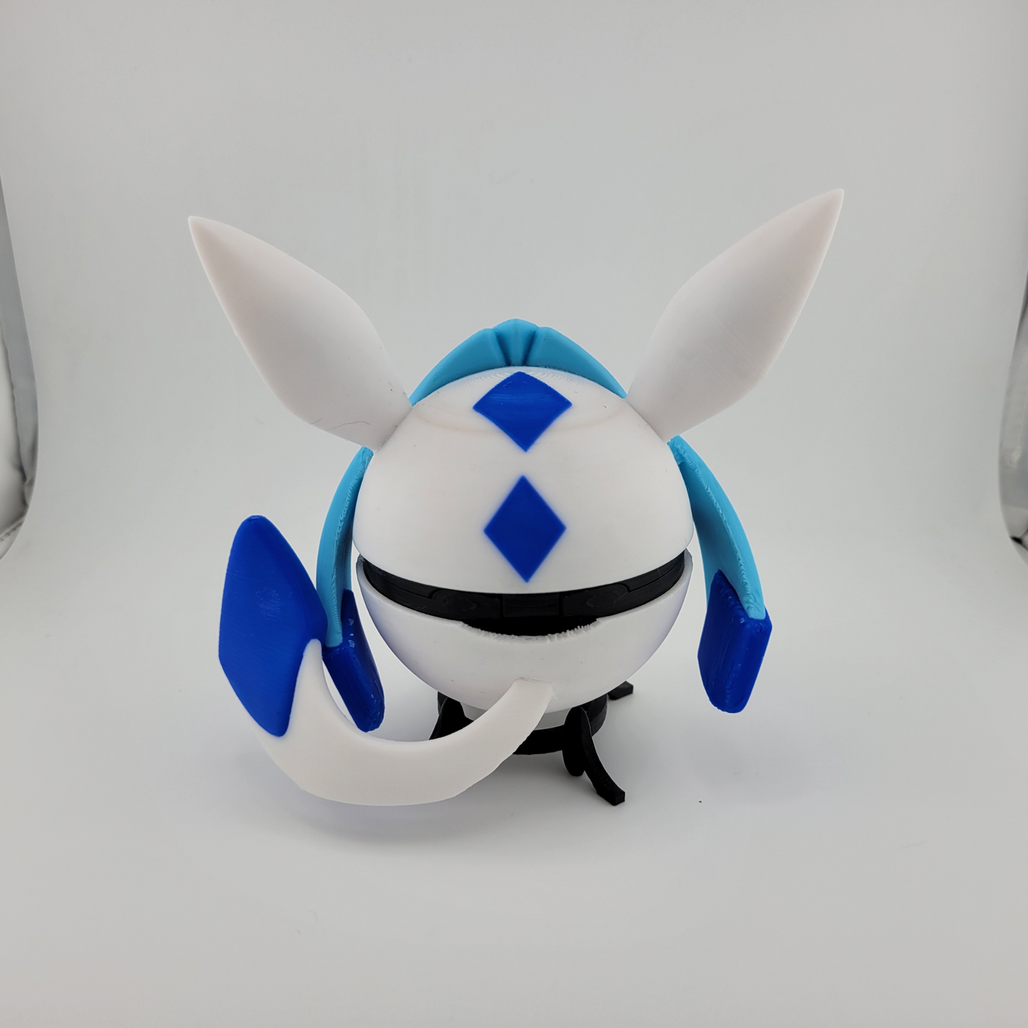 3D printed Glaceon-themed Poké Ball with blue and white icy design and large ears, inspired by Ice-type Pokémon.