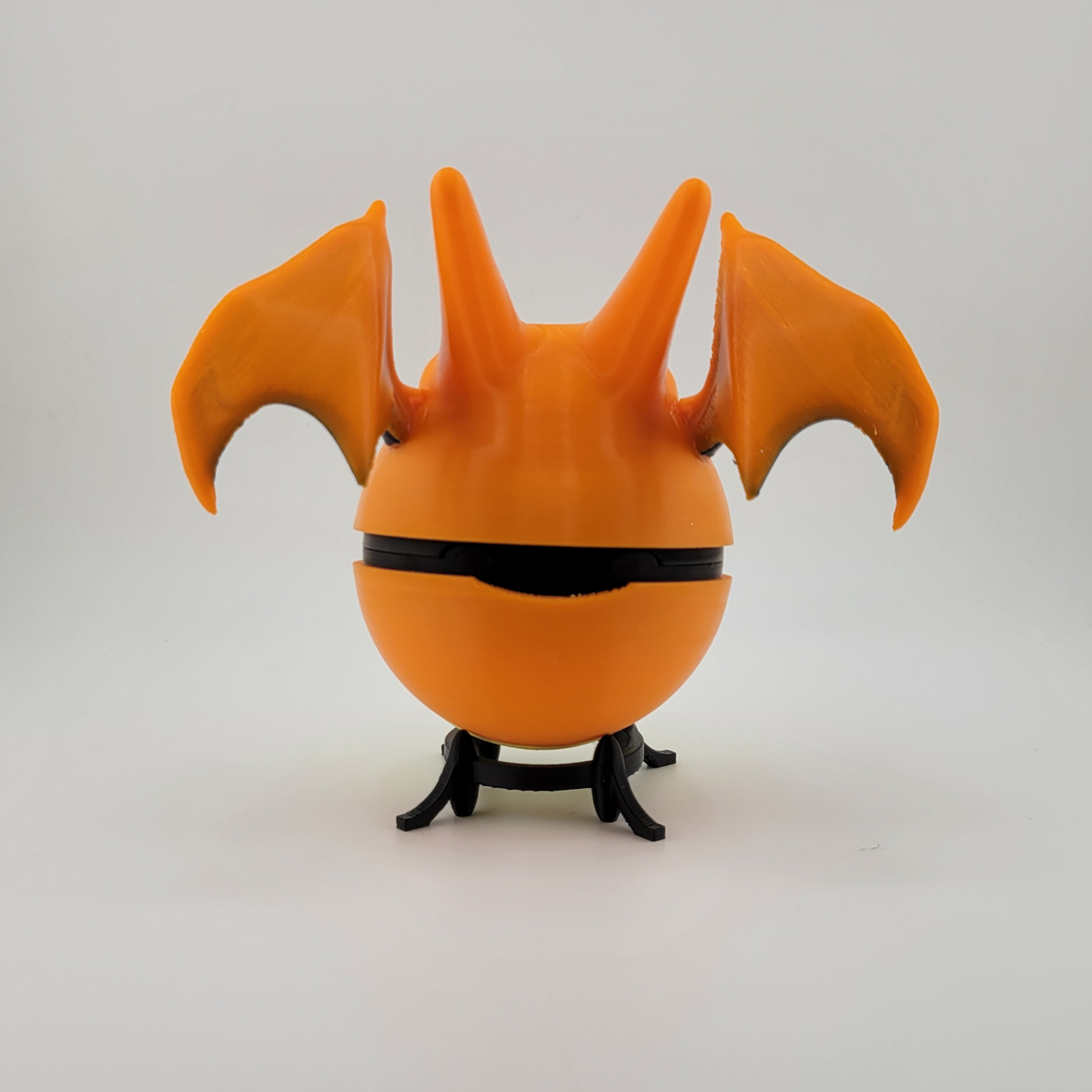 Charizard Pokeball toy made of durable PLA plastic, featuring orange Charizard wings, designed for collectors and gamers.