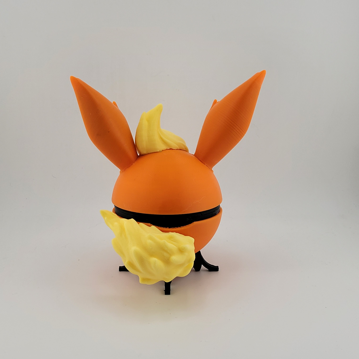 3D printed Flareon Pokeball with orange and yellow details, inspired by Pokémon, handcrafted for collectors and enthusiasts.