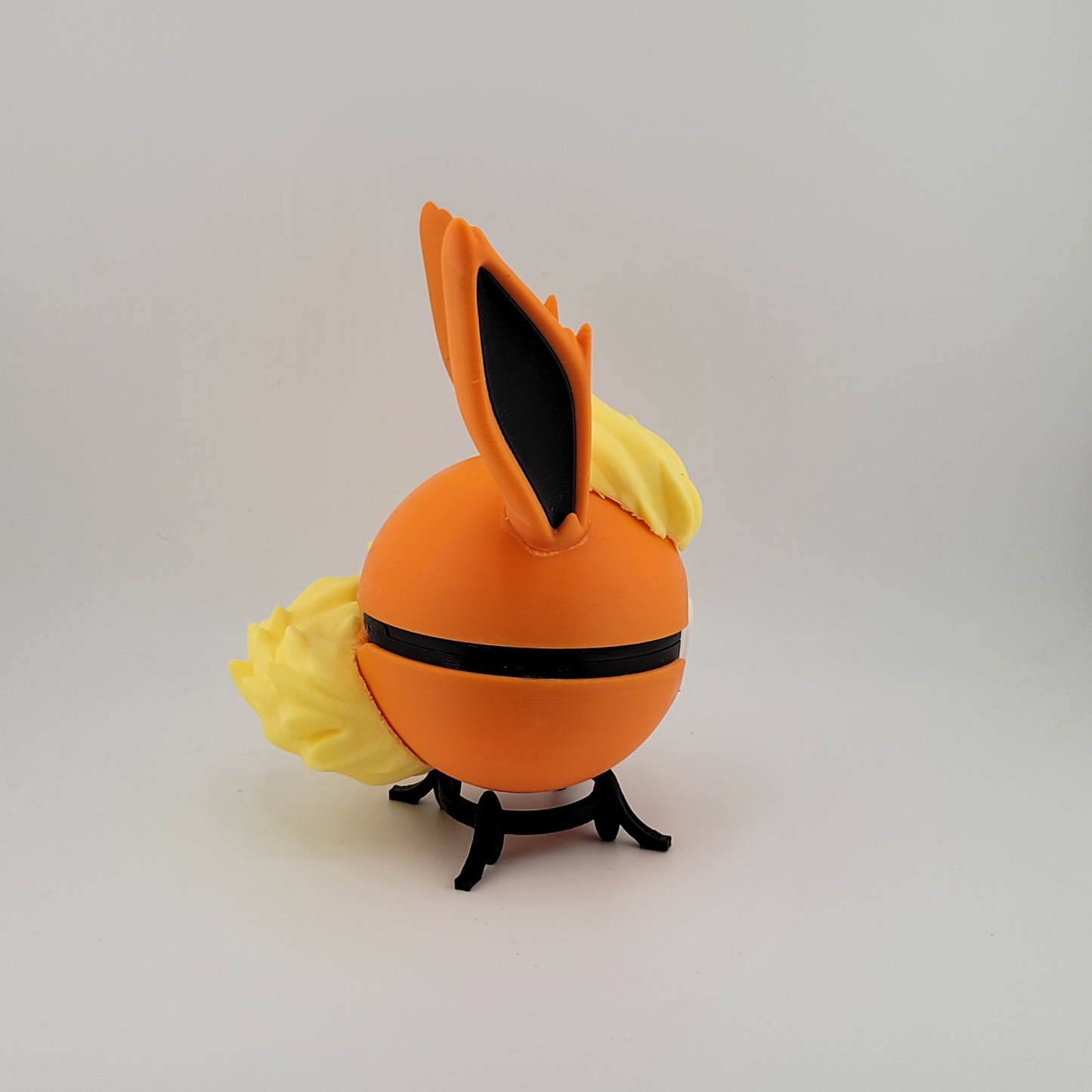 Flareon Pokeball showcasing fiery design with orange and yellow detailing, perfect for Pokémon fans and collectors.