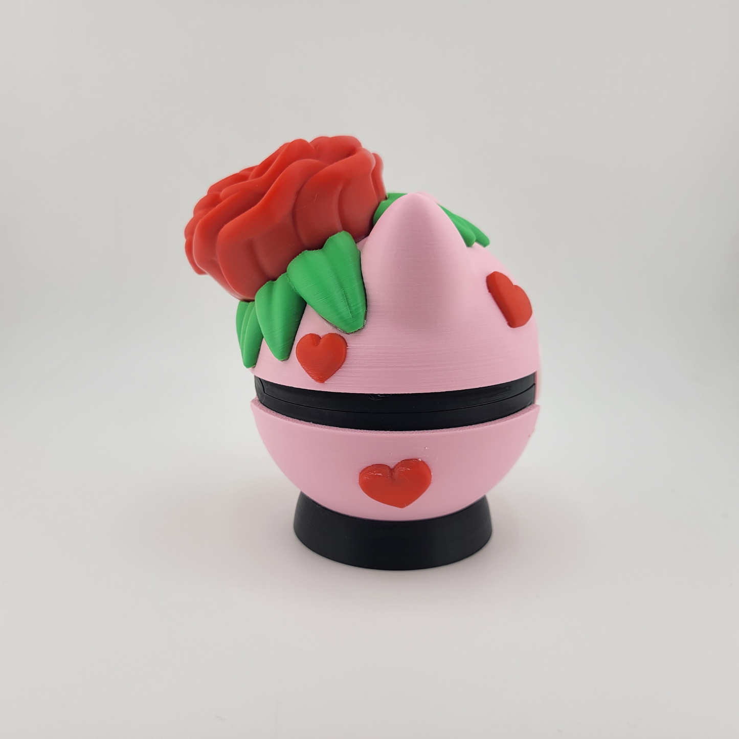 Rose Bulbasaur Pokeball with red rose and green leaves design, pink body, and red heart accents, made of durable PLA plastic.