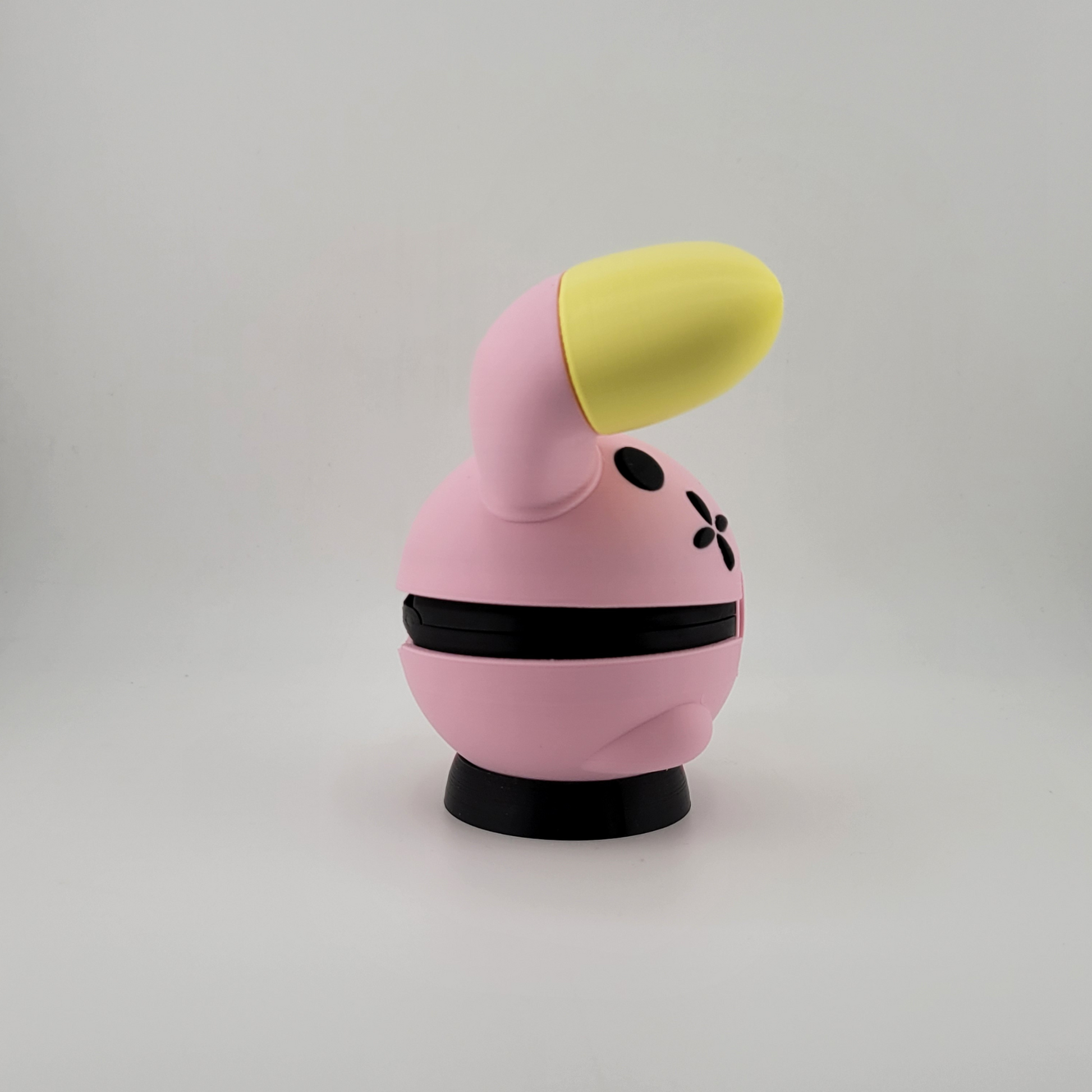 Whismur-themed Poké Ball pink and yellow 3D printed Poké Ball with oversized ears.