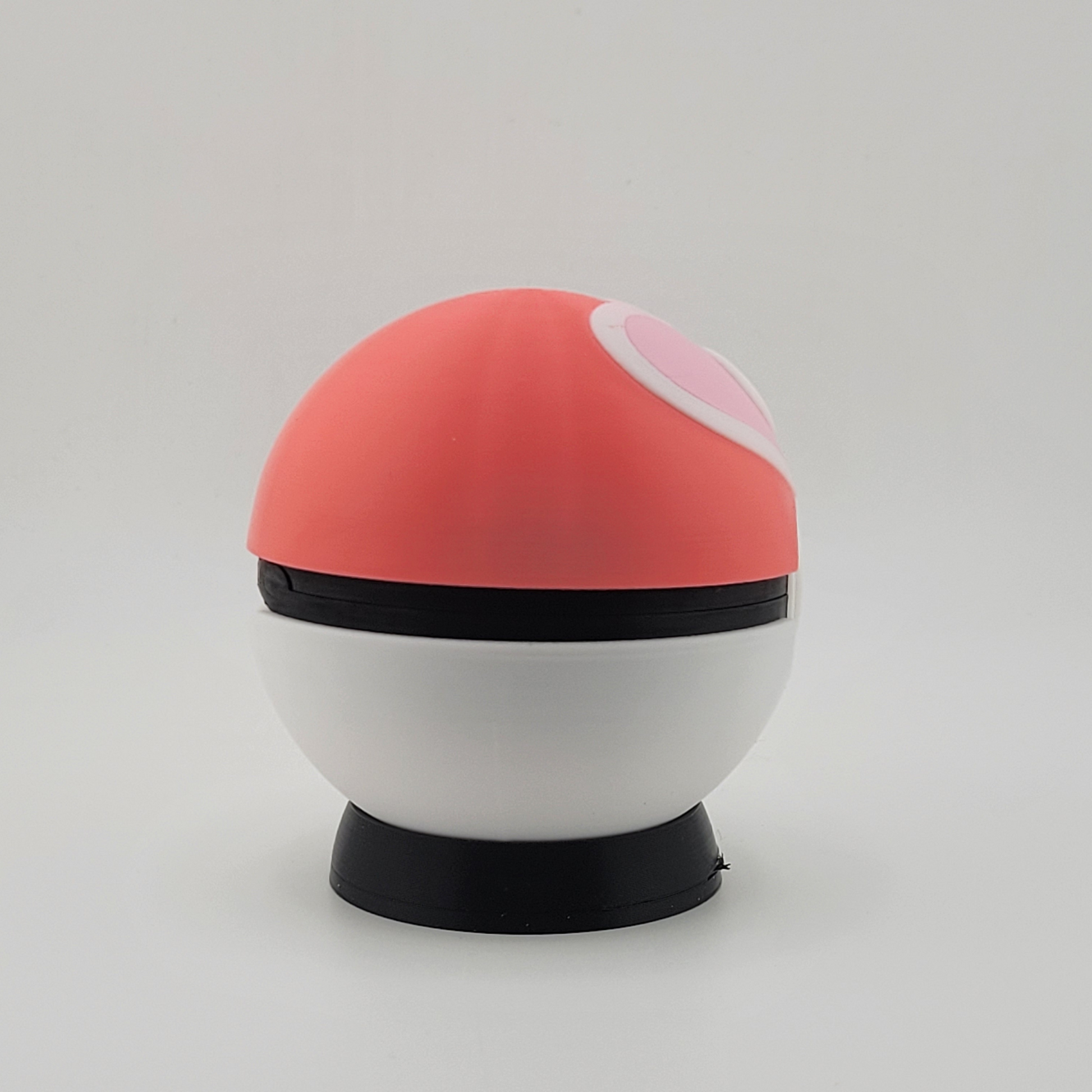 3D printed Loveball with pink and white design, heart center, displayed on stand.