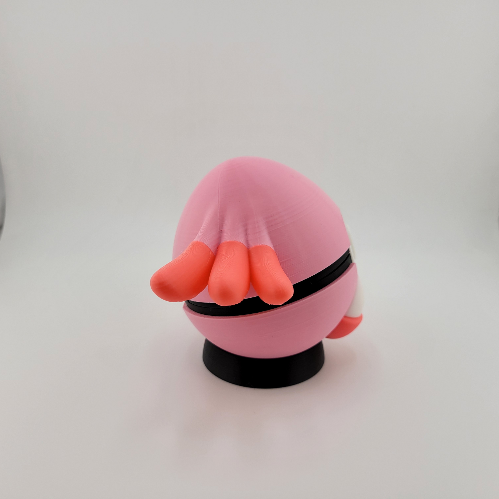 Pink and orange 3D printed Chansey-themed Pokeball on a black stand with latch design.