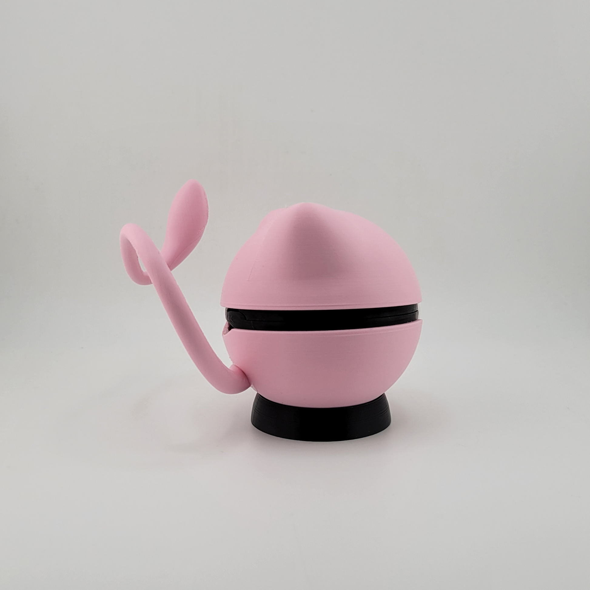 Mew-themed Pokéball in soft pink with tail, 3D printed collectible.