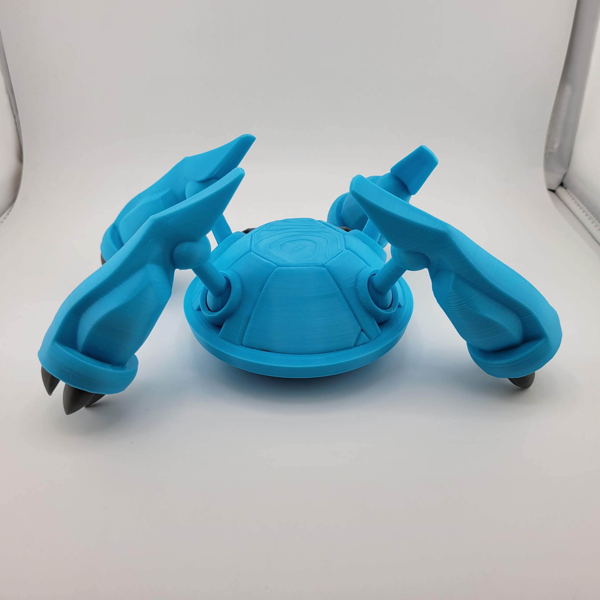 3D printed blue Metagross figurine with articulated limbs.