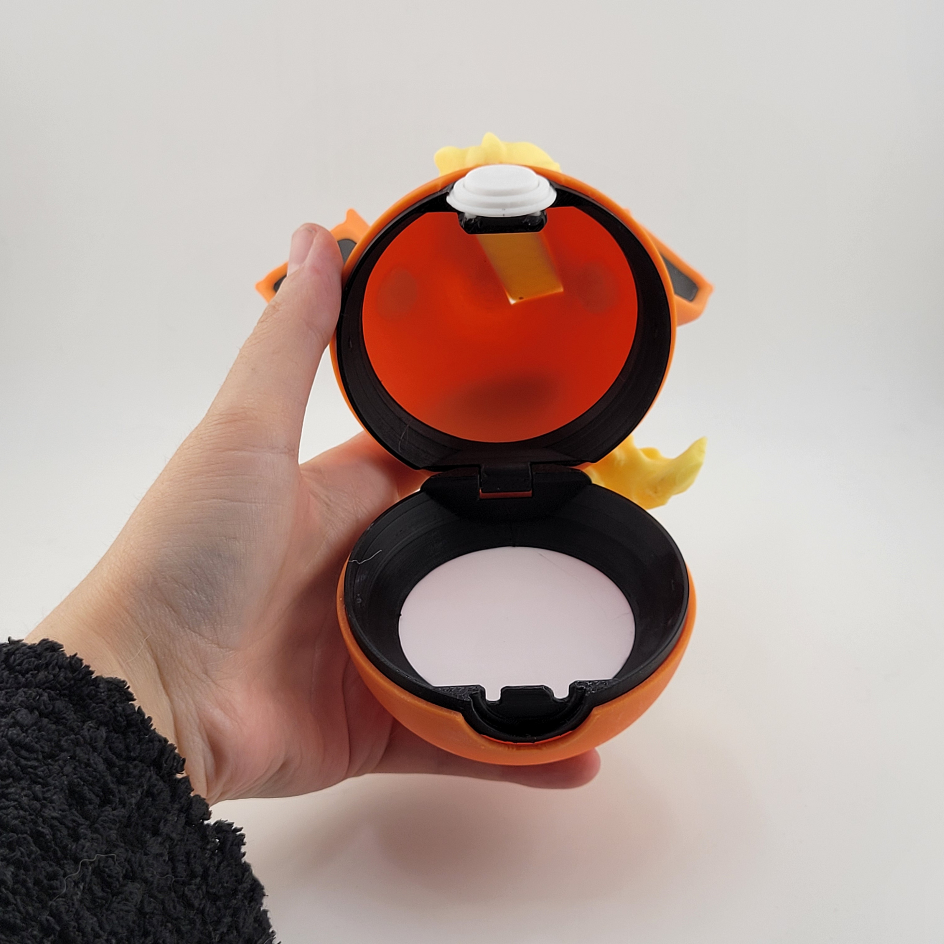 Flareon Pokeball open in a person's hand, showing the detailed interior design.