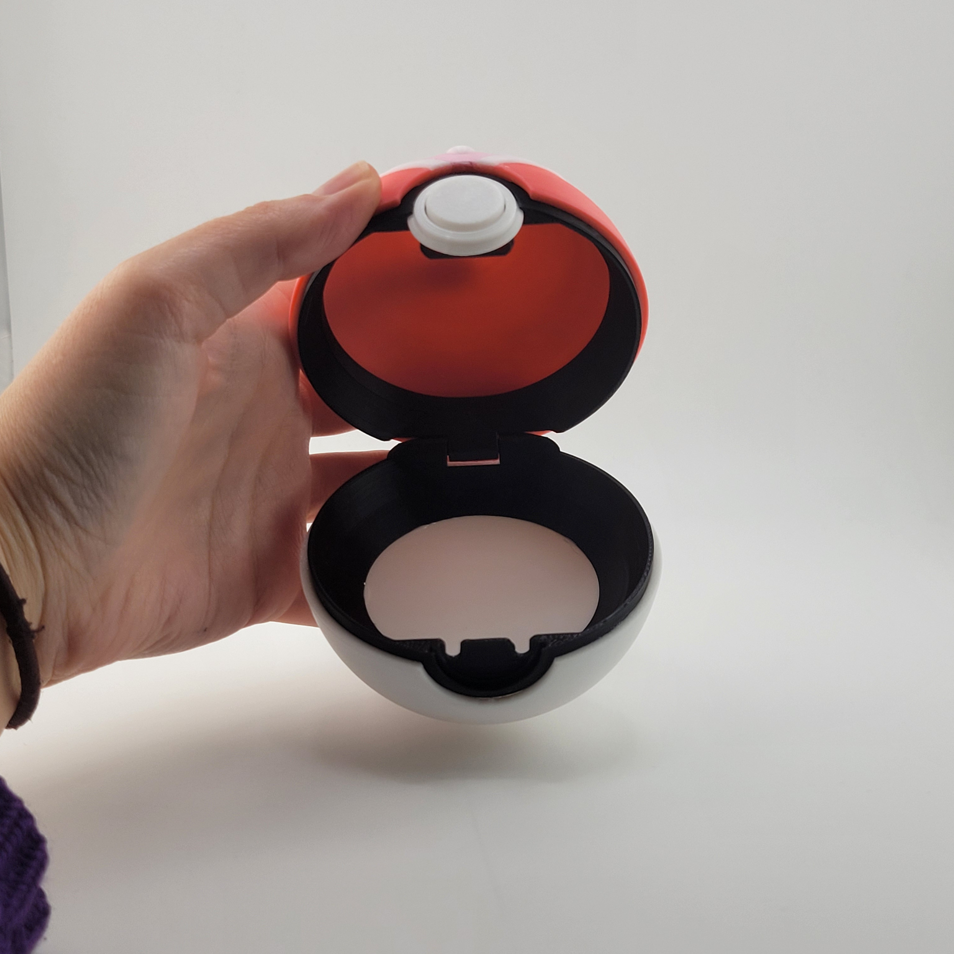 3D printed Loveball with pink and white design, heart center, displayed on stand.
