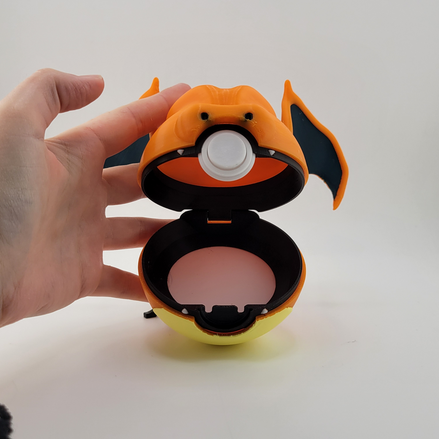 Charizard Pokeball with open latch showing interior, crafted with high-quality PLA and Charizard-inspired details.