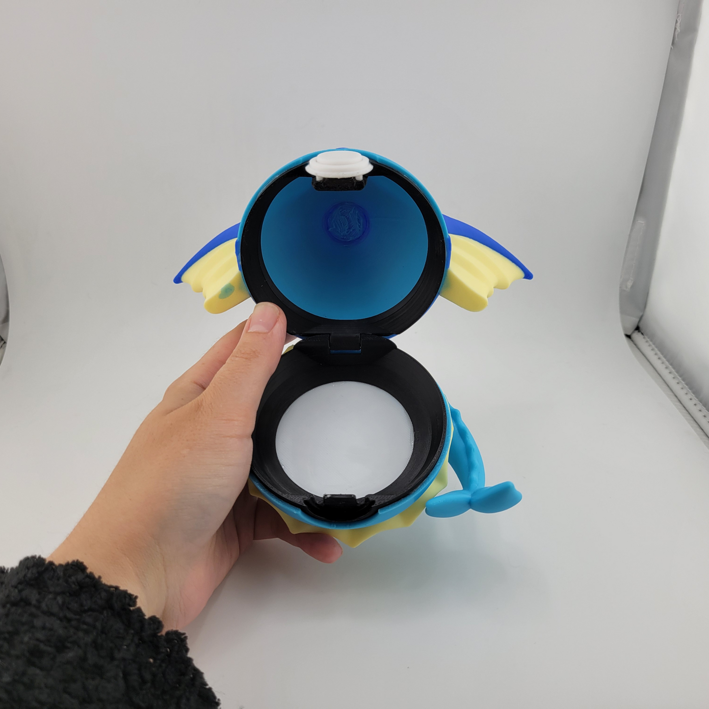 3D printed Vaporeon Pokeball with open latch, handcrafted from durable PLA plastic.