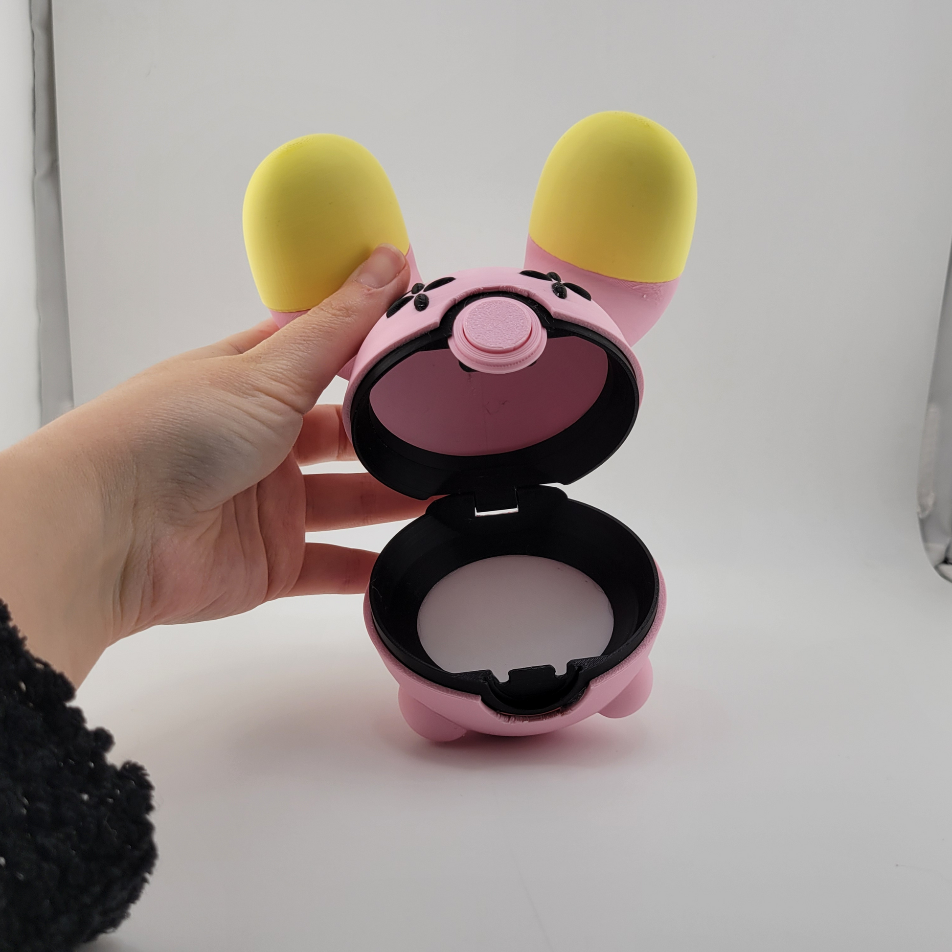Whismur-themed Poké Ball pink and yellow 3D printed Poké Ball with oversized ears.