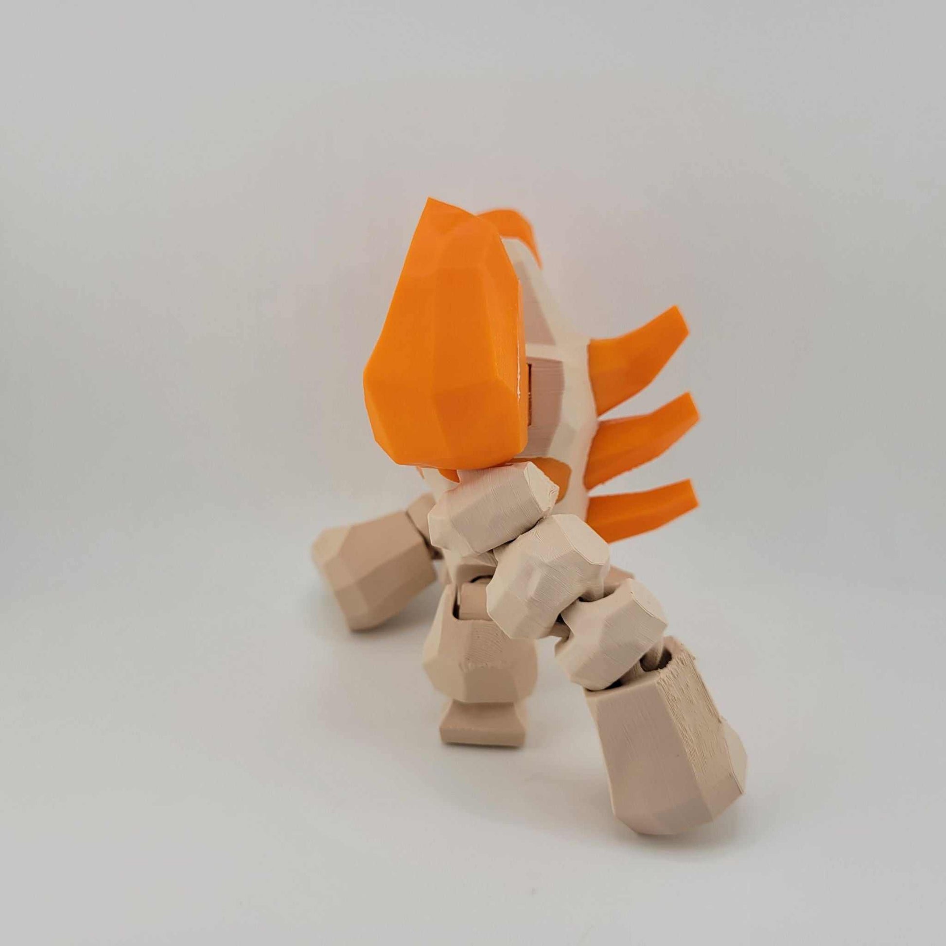 3D printed articulated Regirock figure with orange head and beige boulder-like body in pose against a plain background