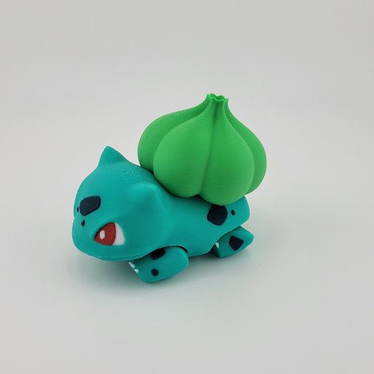 3D printed Bulbasaur toy with green bulb and playful expression.