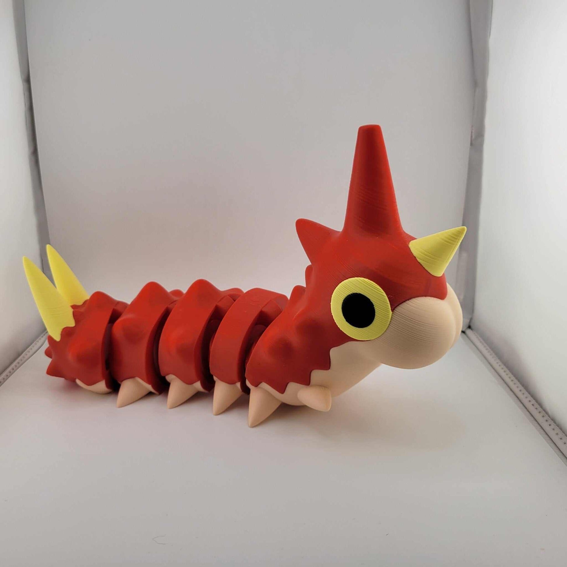 Life sized articulated Wurmple Pokémon figurine in red and yellow, made of durable PLA plastic.