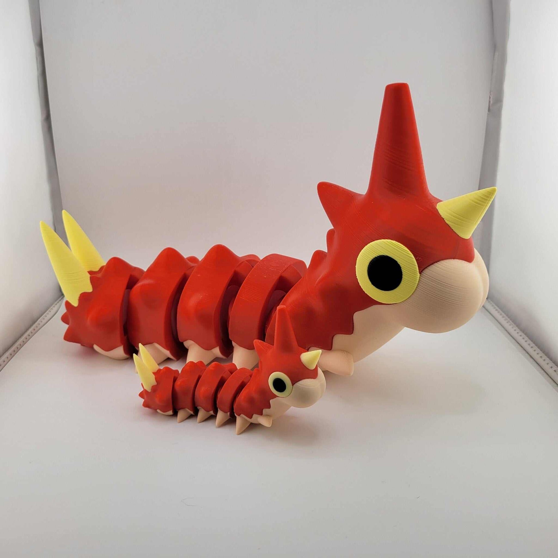 Life-sized articulated Wurmple Pokémon figurine in red and yellow, 3D printed collectible toy.