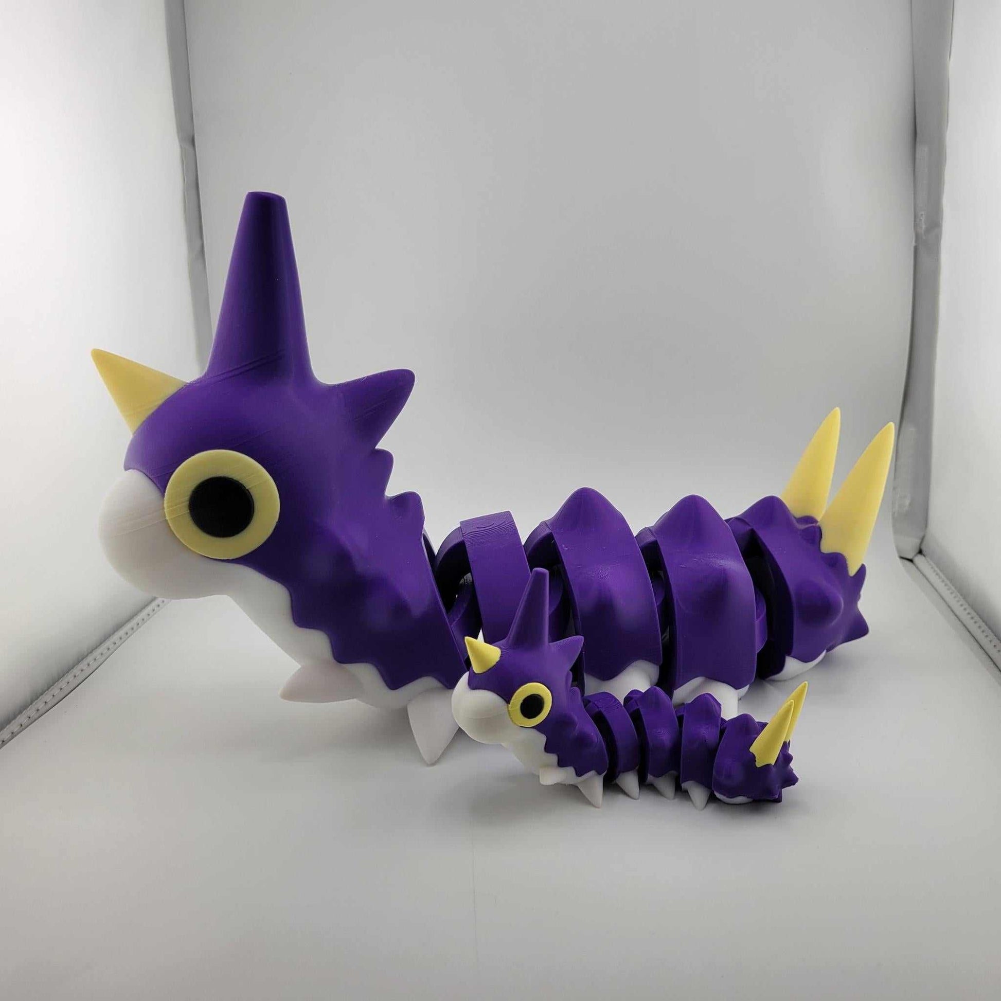 Life-sized purple and yellow articulated Wurmple Pokémon figurine in regular size and smaller version, made from durable PLA plastic.