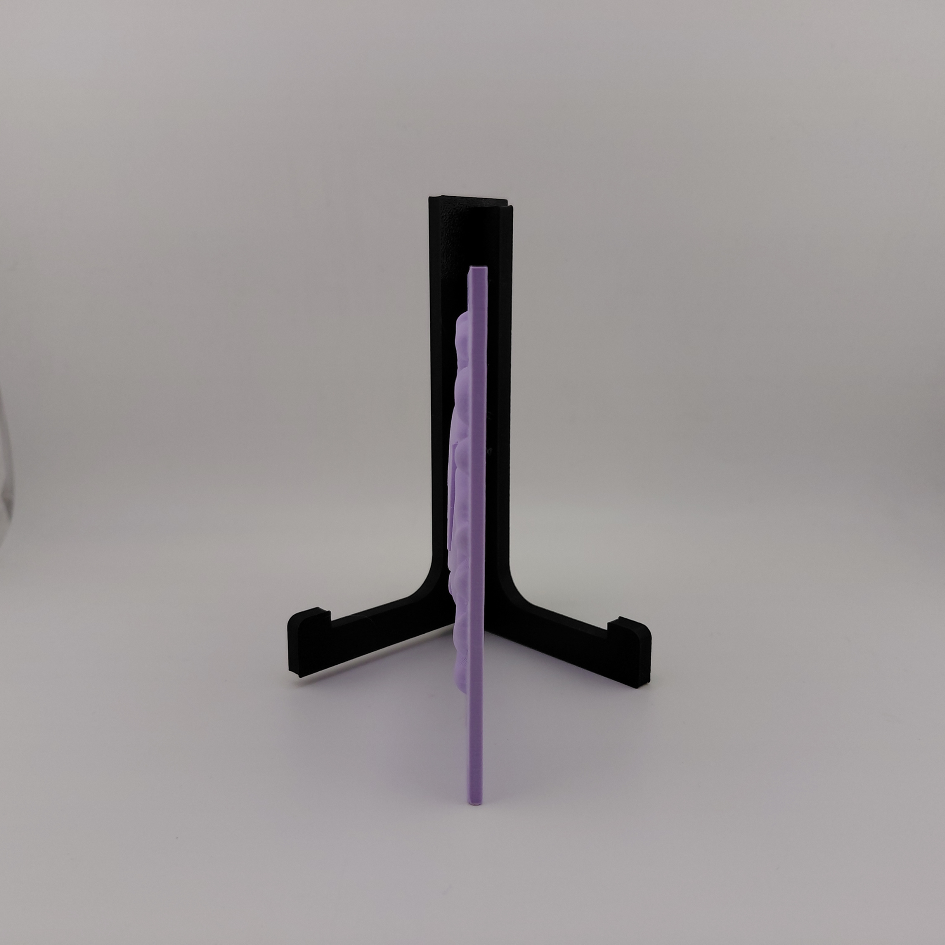 Set of three lavender 3D printed relief plaques featuring Gastly, Haunter, and Gengar inspired ghost monsters displayed on black stands against a white background. Each square plaque has raised detailed artwork and comes with its own stand for desk, shelf, or gaming room decor. Available individually or as a matching set for collectors and fans of spooky monster-inspired decor.