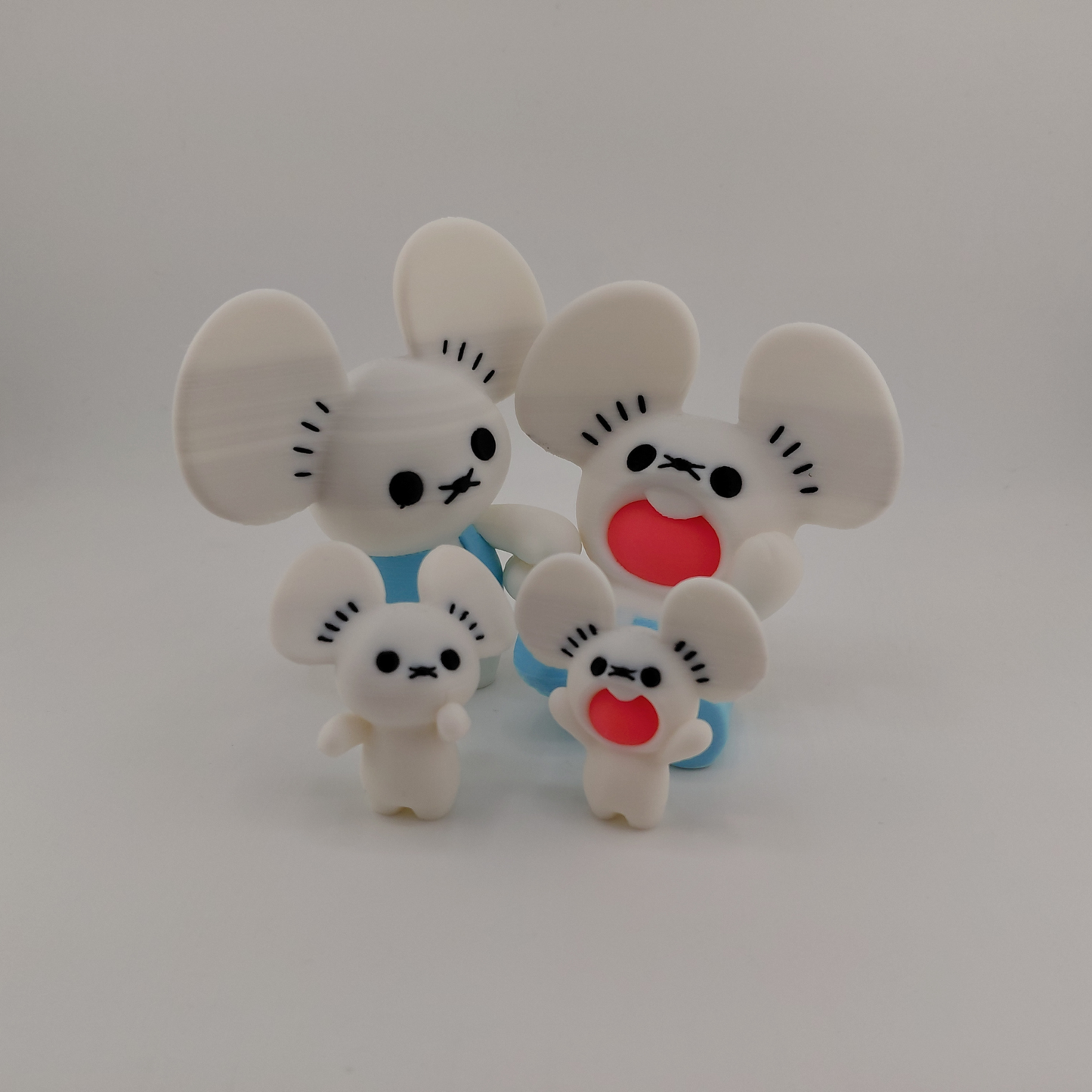 Four white cartoon mouse figurines with black facial features and red mouths, arranged together on a light gray background.