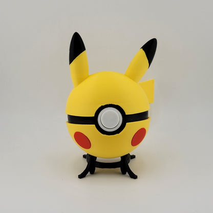 3D printed Pikachu-themed Pokeball with yellow body, black-tipped ears, and red cheeks on a black stand