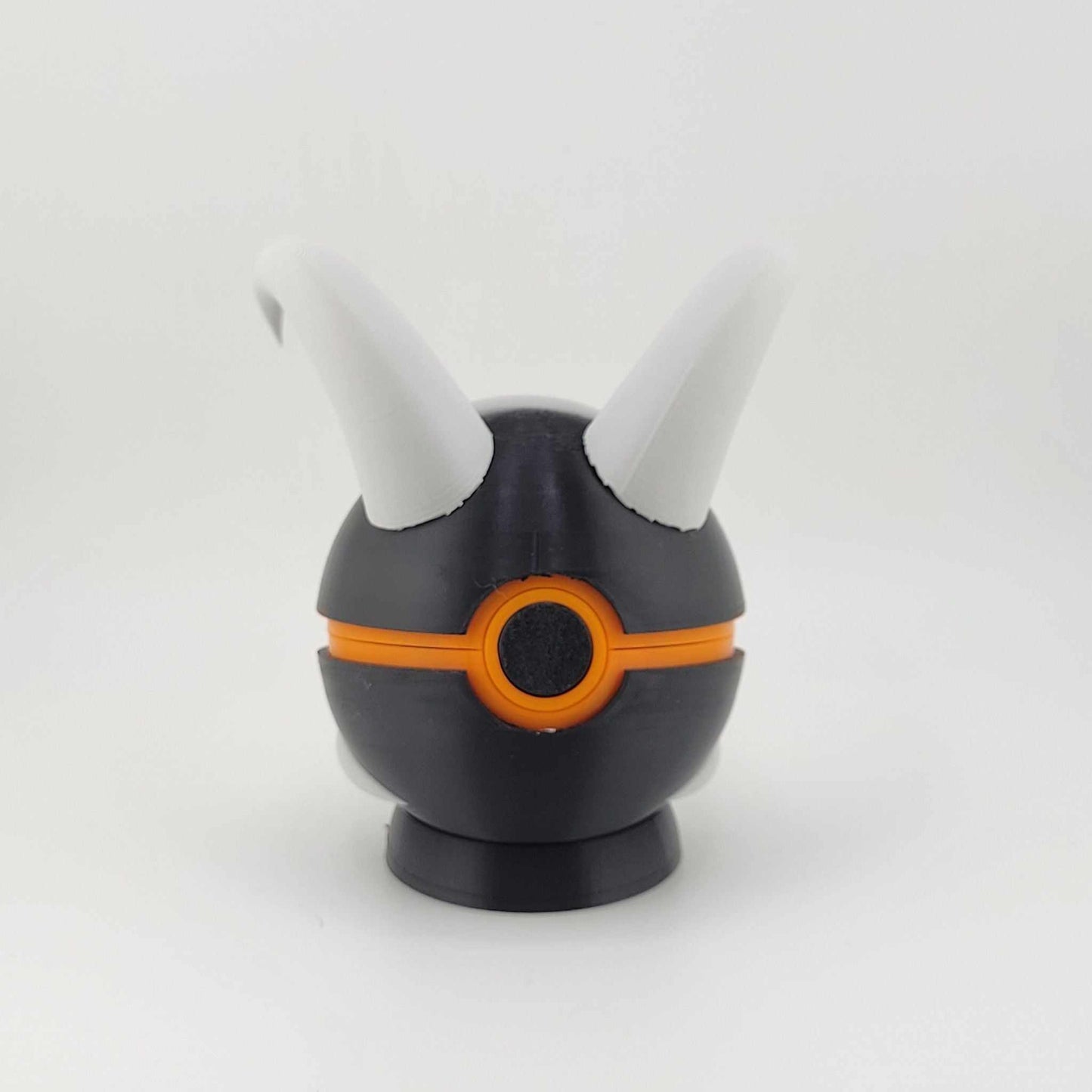 3D printed Houndoom Ball with black and orange design and white horns inspired by Pokémon